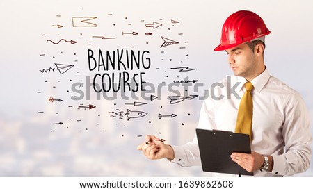 Handsome businessman with helmet drawing BANKING COURSE inscription, contruction sale concept