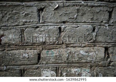 Texture of an old paint covered brick wall. Background image of an abandoned brick wall with painted over paint