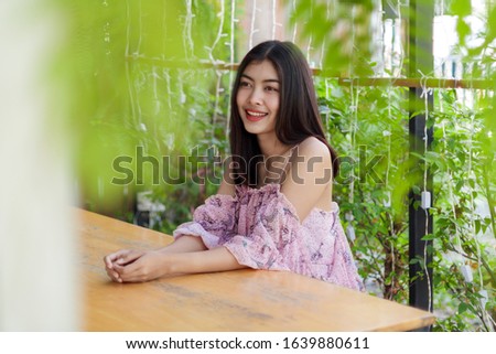 cute girl with pink dress smiling and looking at someone