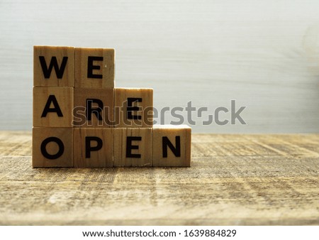 We are open alphabet letters on wooden background