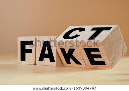 Flipping wooden cubes for change wording from "fact" to "fake". Royalty-Free Stock Photo #1639894747