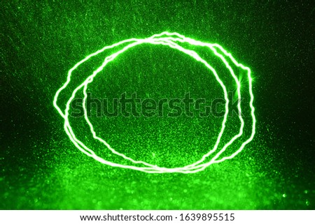 Green rays, lightning and glitter on a black background