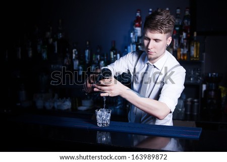 Bartender bartender is pouring a drink Royalty-Free Stock Photo #163989872