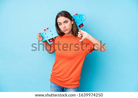Young caucasian skater woman isolated showing a dislike gesture, thumbs down. Disagreement concept.
