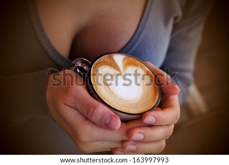 woman hands with cappuccino  on a wood table