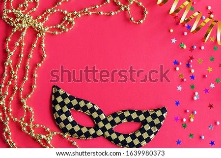 Festive mask with decor on a red background. Carnival celebration concept, Mardi Gras, Brazilian carnival, Venice carnival, carnival costume, spring. Flat lay, top view, place for text