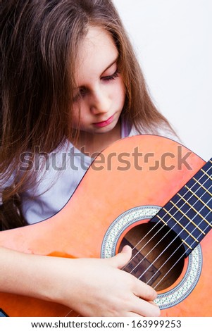 little girl playing a guitar