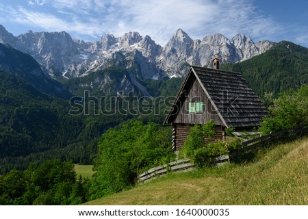 Alpine hut in front of the impressive Julian Alps in Kranjska Gora, Slovenia Royalty-Free Stock Photo #1640000035