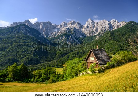 chalet in front of an impressive mountain backdrop Julian Alps in Kranjska Gora, Slovenia Royalty-Free Stock Photo #1640000053