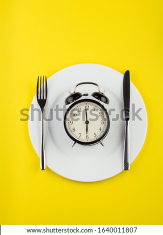 weight loss or diet concept. stock image of alarm clock on plate