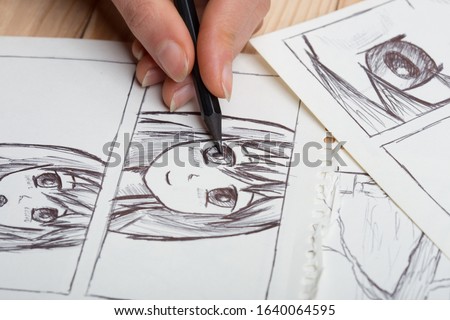 Artist drawing an anime comic book in a studio. Royalty-Free Stock Photo #1640064595