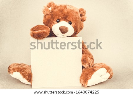 Teddy bear holding a place for text from craft cartoon paper. Vintage retro romantic style. Unusual creative greeting card. Family, birthday baby and friendship. Template.