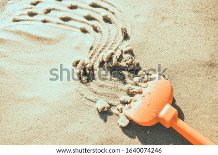 Drawing on the sand on beach made by toy rake