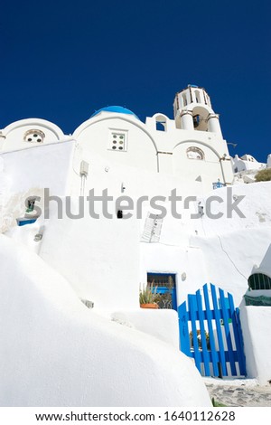 Whitewashed Santorini village hillside view dominated by sky blue gate