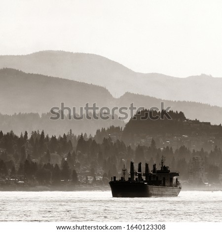 Abstract background of mountain range and city buildings and a cargo ship in Vancouver.
