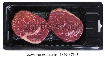 Two steaks in vacuum packaging isolated on white background, top view