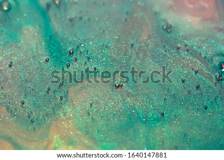 green and pink alcohol ink with glitter dissolved in water, abstract background, macro shot