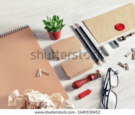 Blank kraft paper stationery set on light wood table background. Template for branding identity. For graphic designers presentations and portfolios.