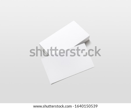 Photo of blank business cards with soft shadows on light gray background. For design presentations and portfolios. Isolated with clipping path.