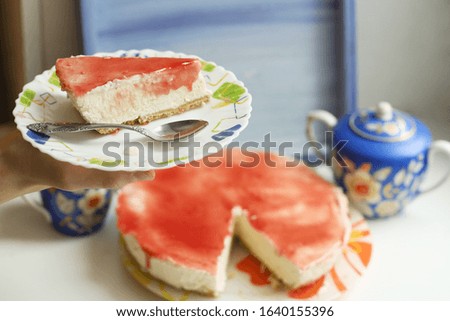 cheese cake with strawberry jam topping close up photo with tea set