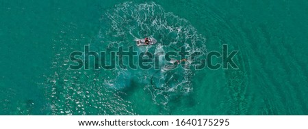 Aerial drone ultra wide photo of water sports in Super Paradise beach in island of Mykonos, Cyclades, Greece