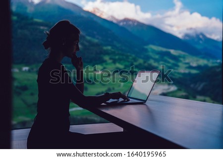 Silhouette view of woman digital nomad working with business project via netbook application, female freelancer watching video on laptop computer typing content publication via good 4g Connection