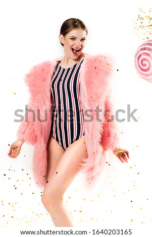 Party for a girl.on white , pink balls. Girl in a pink fur coat and swimsuit .sweet girl dancing and singing. Vertical portrait.