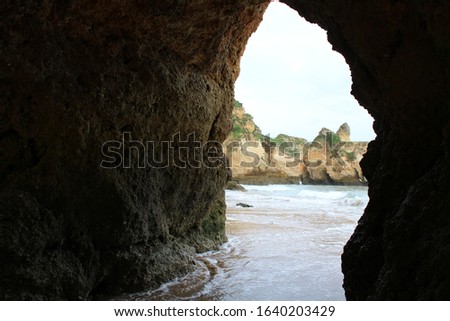 inside a cave on the beach with the light coming in and special effects on the beach in Alvor, Algarve, Portugal. Famous cellars near benagil