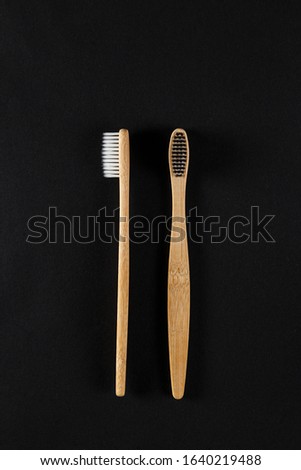 Eco-friendly bamboo toothbrushes against a dark background. Responsible consumption concepts.
