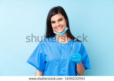 Young woman dentist holding tools over isolated blue background applauding Royalty-Free Stock Photo #1640232961