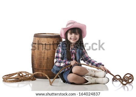 Adorable little girl dressed as a cowgirl.  Isolated on white.