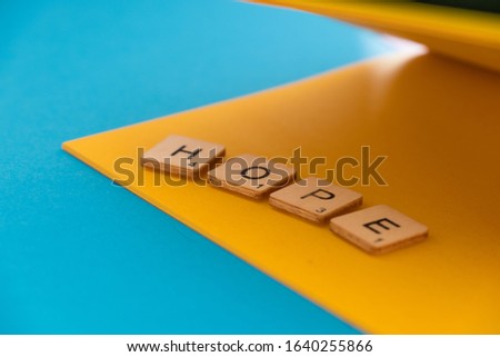 Hope: square wooden letters on a blue and yellow background