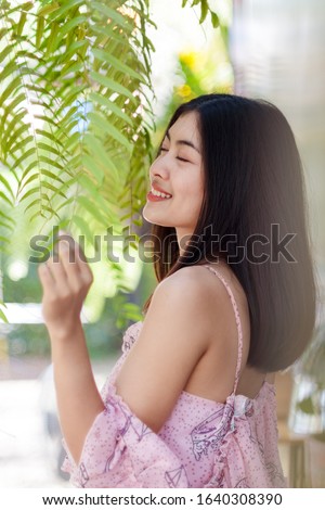 Cute girl with pink dress closing her eyes and smiling, half shot