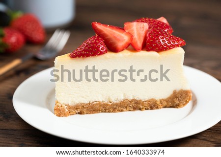 Cheesecake slice with strawberries. Plain New York Classical Style cheesecake on white plate closeup view Royalty-Free Stock Photo #1640333974