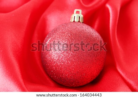 Beautiful Christmas ball on red satin cloth