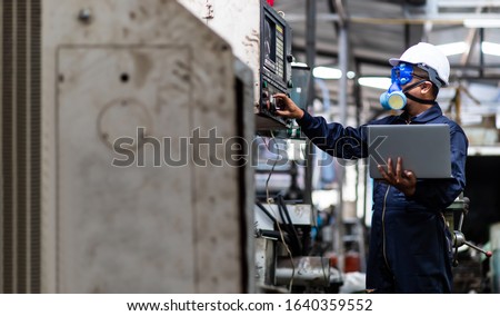 Officials from the Department of Hazardous substances control bureau is investigating the leak of a hazardous chemical in a chemical plant. Man with protective mask and computer laptops in factory Royalty-Free Stock Photo #1640359552