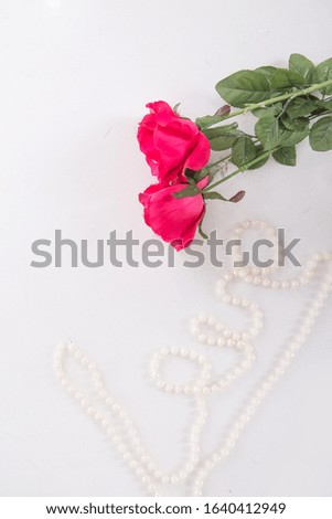 red roses and the inscription with beads love on a white background. concept of international women's day, spring, March 8, birthday