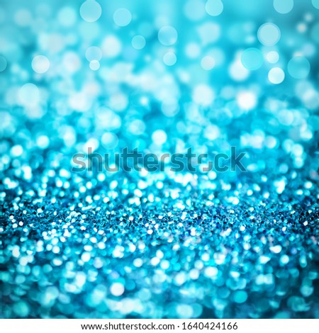 Defocused blue glitter and shimmer on abstract bokeh background