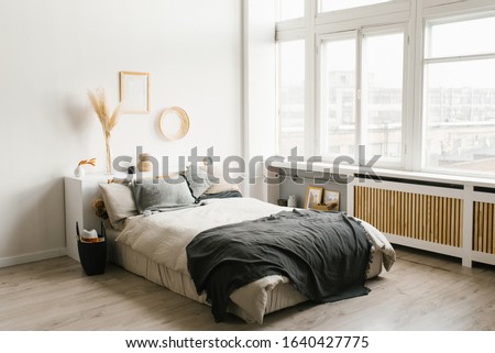 Bedroom interior in Scandinavian minimalist style in white and gray color scheme with large Windows. Royalty-Free Stock Photo #1640427775
