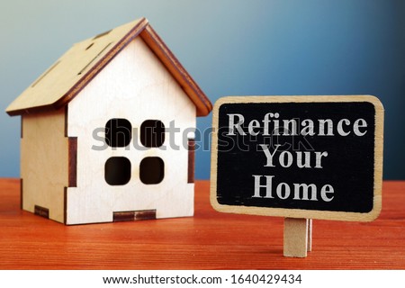 Refinance Your Home mortgage board and wooden house. Royalty-Free Stock Photo #1640429434