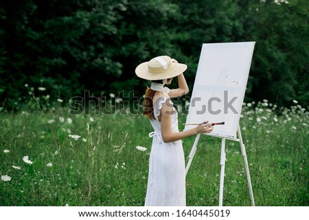 young woman on canvas draws paintings
