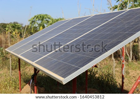 Close up outdoor view of solar panels located in a rural garden in Benin in order to supply energy for a pumping system. African agricultural picture of a traditional technology.