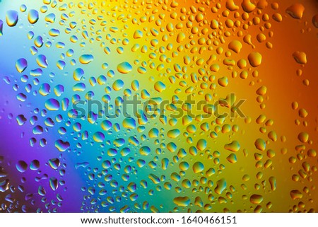 Reflection of the rainbow in the raindrops on the glass.