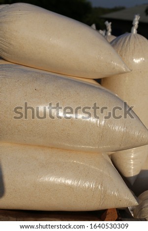 Outdoor view of rows of plastic bags full of white cassava flour called garri. Picture taken in Benin, west africa, december 2019. Traditional shops located in the border of the roads.   