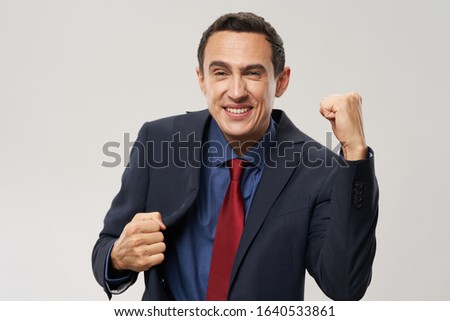 A man in a suit blue shirt red tie