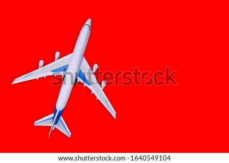 Toy airplane on a red background. Top view, copy space.