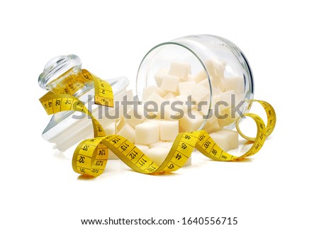 sugar cubes spilled from overturned glass sugar bowl and wrapped by tape measure isolated on white background Royalty-Free Stock Photo #1640556715