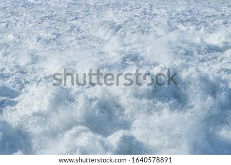 Sea waves and foam during the surf. Nazare, Portugal