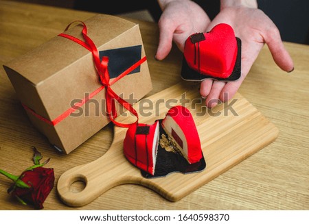 A woman holds a heart-shaped dessert. Gift for February 14, food and love