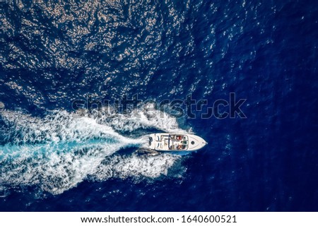 Aerial top down view of a speedboat travelling over blue, mediterranean sea with copy space
